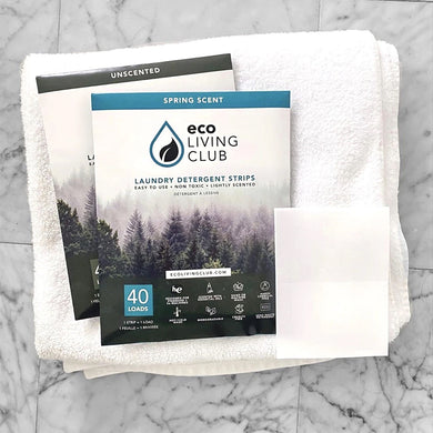 two packages and strips of Eco Laundry Detergent Strips on folded towels