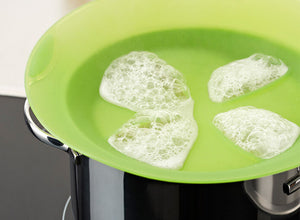 The Lekue Non-Spill Lid retaining some water boiling up from a pot